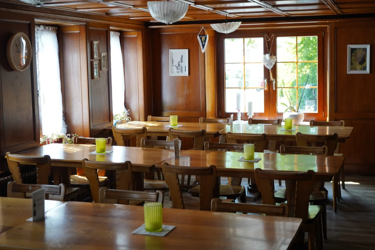 Der Essensbereich eines Restaurants, der vollständig in Holz gekleidet ist.